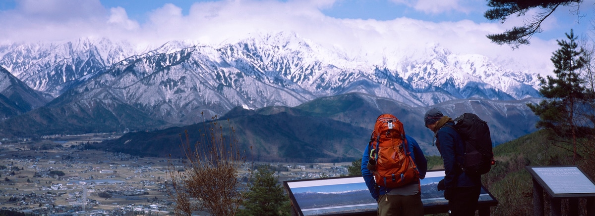 Panorama of hikers studying a panorama of the surrounding mountains in Omachi, Japan. Taken by Lucas Taylor on a Hasselblad XPan camera.