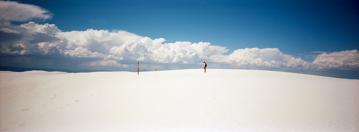 Person standing in the White Sands desert in New Mexico, USA. Taken by Lucas Taylor on a Hasselblad XPan camera.